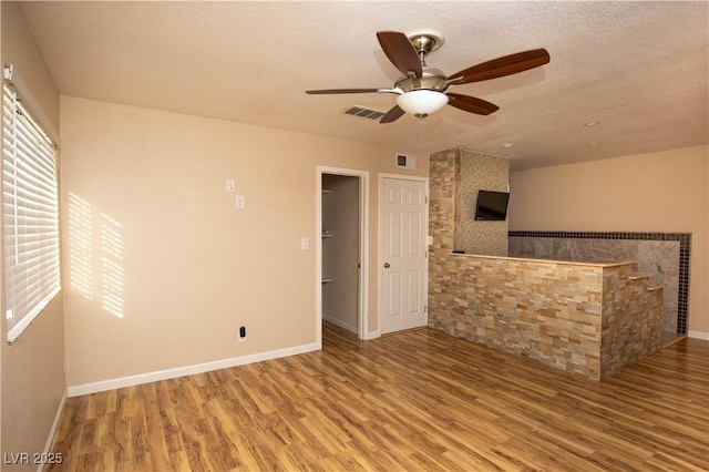 1340 Lucky St, Las Vegas, NV 89104 - unfurnished living room featuring wood finished floors, a ceiling fan, and a textured ceiling