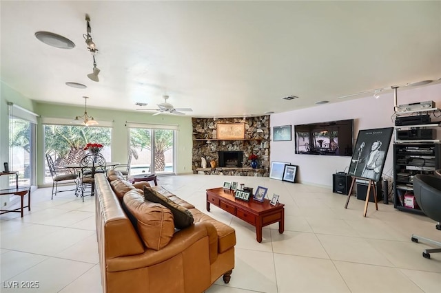 2770 La Casita Ave, Las Vegas, NV 89120 - living room with track lighting, tile patterned flooring, ceiling fan, and a stone fireplace