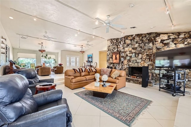 2770 La Casita Ave, Las Vegas, NV 89120 - living area with rail lighting, a ceiling fan, light tile patterned floors, and a stone fireplace