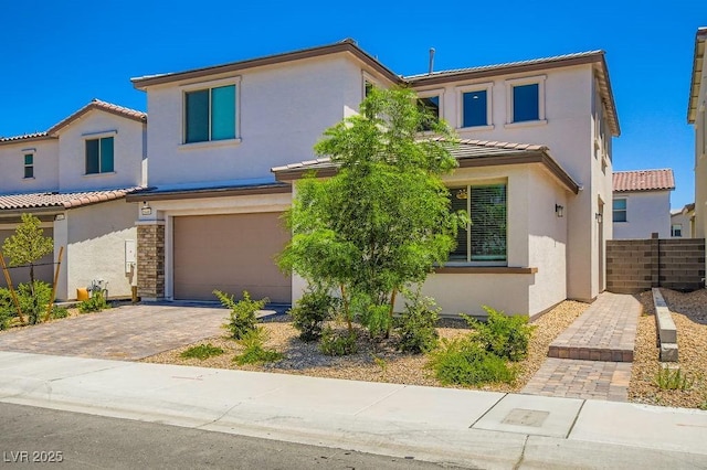 9440 Lunar Ray St, Las Vegas, NV 89143 - view of front facade with an attached garage, stucco siding, decorative driveway, and a tile roof