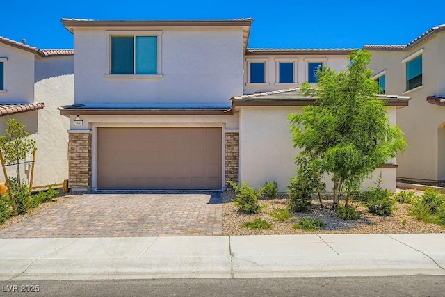 9440 Lunar Ray St, Las Vegas, NV 89143 - view of front of house featuring stone siding, a garage, decorative driveway, stucco siding, and a tile roof