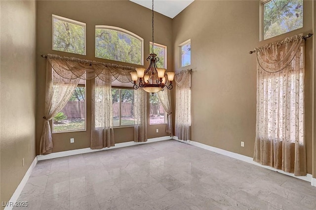 229 N Buteo Woods Ln, Las Vegas, NV 89144 - spare room featuring a chandelier and a towering ceiling
