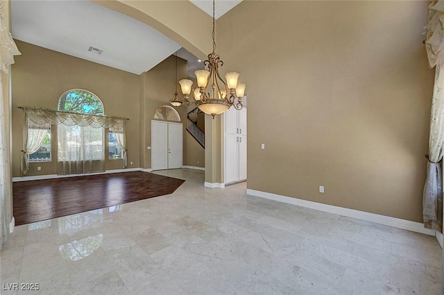 229 N Buteo Woods Ln, Las Vegas, NV 89144 - entrance foyer with high vaulted ceiling, arched walkways, a chandelier, light marble finish floors, and stairway