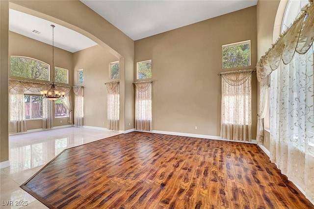 229 N Buteo Woods Ln, Las Vegas, NV 89144 - unfurnished room with a high ceiling, a chandelier, wood finished floors, and arched walkways