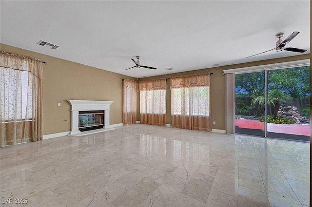 229 N Buteo Woods Ln, Las Vegas, NV 89144 - unfurnished living room with ceiling fan, light marble finish flooring, and a glass covered fireplace