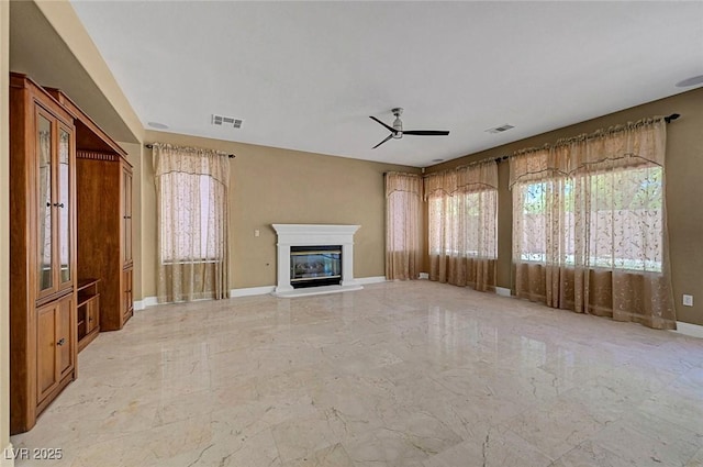 229 N Buteo Woods Ln, Las Vegas, NV 89144 - unfurnished living room featuring light marble finish flooring, a ceiling fan, and a glass covered fireplace