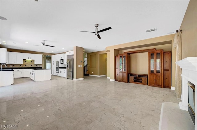 229 N Buteo Woods Ln, Las Vegas, NV 89144 - unfurnished living room with ceiling fan, a premium fireplace, light marble finish flooring, recessed lighting, and plenty of natural light
