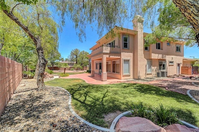 229 N Buteo Woods Ln, Las Vegas, NV 89144 - rear view of house with a balcony, a fenced backyard, a patio, stucco siding, and a chimney
