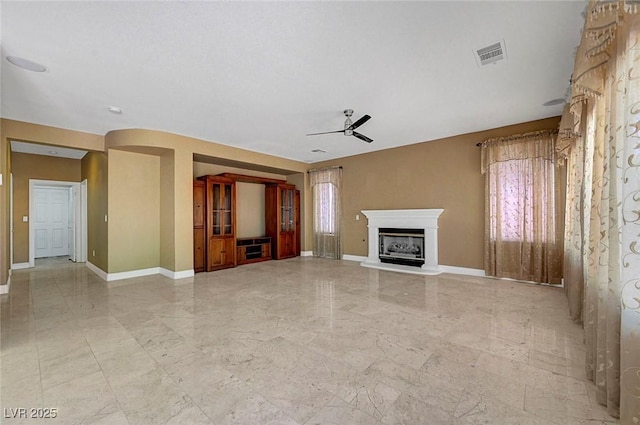 229 N Buteo Woods Ln, Las Vegas, NV 89144 - unfurnished living room with ceiling fan, a fireplace with raised hearth, and light marble finish flooring