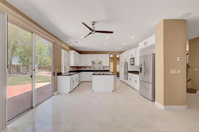 229 N Buteo Woods Ln, Las Vegas, NV 89144 - kitchen featuring appliances with stainless steel finishes, dark countertops, a ceiling fan, a center island, and white cabinets
