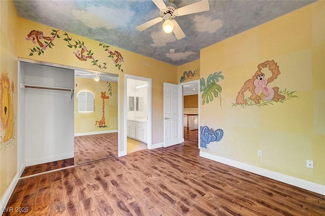 229 N Buteo Woods Ln, Las Vegas, NV 89144 - unfurnished bedroom with wood finished floors, ensuite bathroom, ceiling fan, and a closet