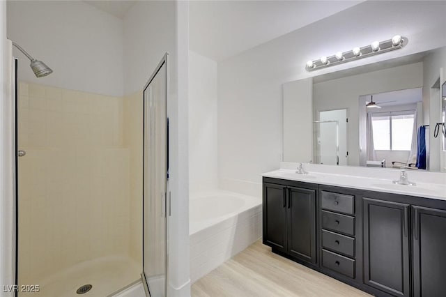 201 Crown Imperial St, Henderson, NV 89074 - full bathroom featuring a garden tub, double vanity, a stall shower, wood finished floors, and ceiling fan