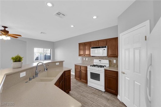 8658 Tom Noon Ave Unit 103, Las Vegas, NV 89178 - kitchen featuring white appliances, tasteful backsplash, light countertops, light wood-style floors, and recessed lighting