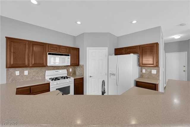 8658 Tom Noon Ave Unit 103, Las Vegas, NV 89178 - kitchen with white appliances, light countertops, backsplash, brown cabinets, and recessed lighting