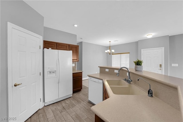 8658 Tom Noon Ave Unit 103, Las Vegas, NV 89178 - kitchen featuring white appliances, a chandelier, light wood-type flooring, light countertops, and recessed lighting