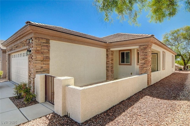 2508 Chasma Dr, Henderson, NV 89044 - view of side of property with a fenced front yard, stucco siding, an attached garage, stone siding, and a gate