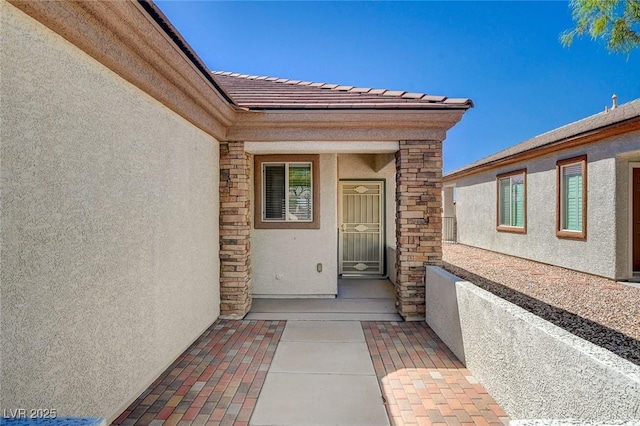 2508 Chasma Dr, Henderson, NV 89044 - view of exterior entry featuring stucco siding, stone siding, and a tile roof