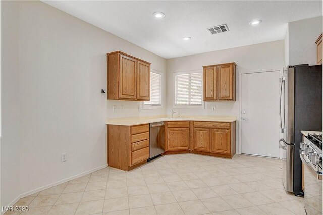 2508 Chasma Dr, Henderson, NV 89044 - kitchen featuring stainless steel appliances, built in desk, light countertops, brown cabinets, and recessed lighting