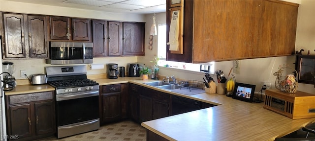 1886 Ludington Ave, Las Vegas, NV 89156 - kitchen with stainless steel appliances, light countertops, and dark brown cabinets