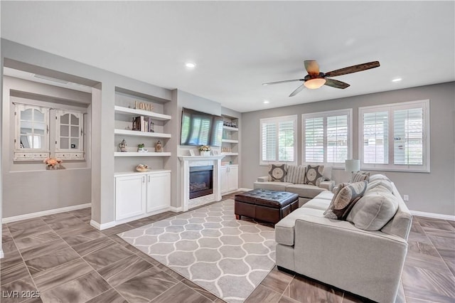 2433 Amatrice St, Henderson, NV 89044 - living room with ceiling fan, a glass covered fireplace, built in shelves, and recessed lighting