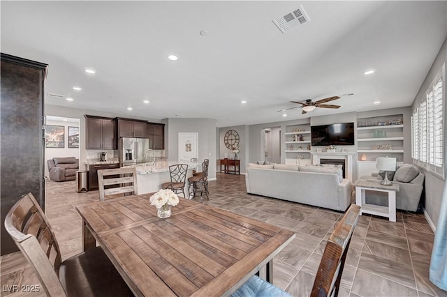 2433 Amatrice St, Henderson, NV 89044 - dining area with recessed lighting, a ceiling fan, built in features, and a fireplace