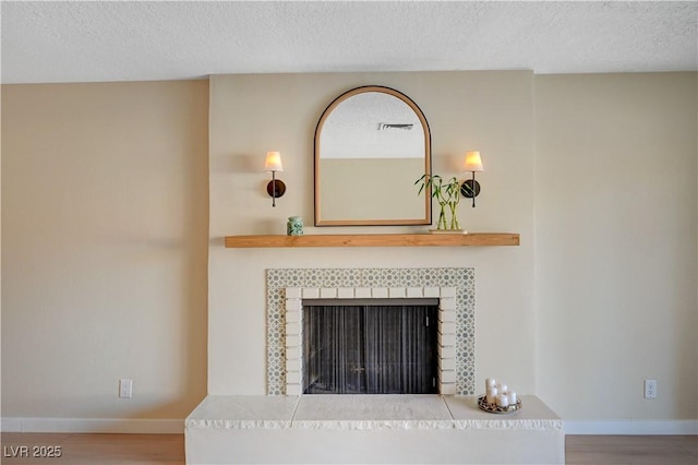1905 Plaza Del Padre, Las Vegas, NV 89102 - detailed view of wood finished floors, a tile fireplace, and a textured ceiling