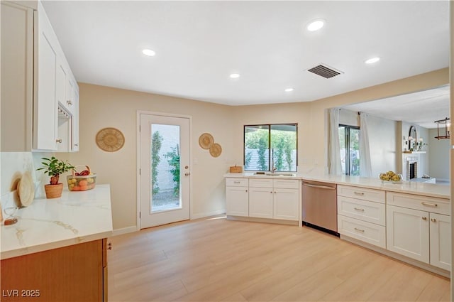 1905 Plaza Del Padre, Las Vegas, NV 89102 - kitchen featuring stainless steel dishwasher, light stone counters, light wood-style floors, recessed lighting, and white cabinets