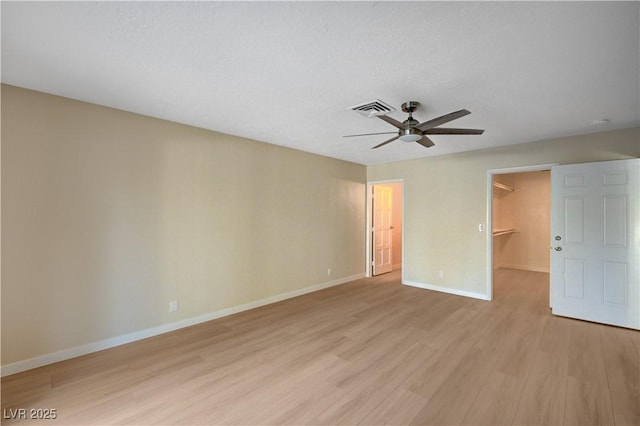 1905 Plaza Del Padre, Las Vegas, NV 89102 - unfurnished bedroom featuring a walk in closet, light wood-style floors, a closet, and a ceiling fan