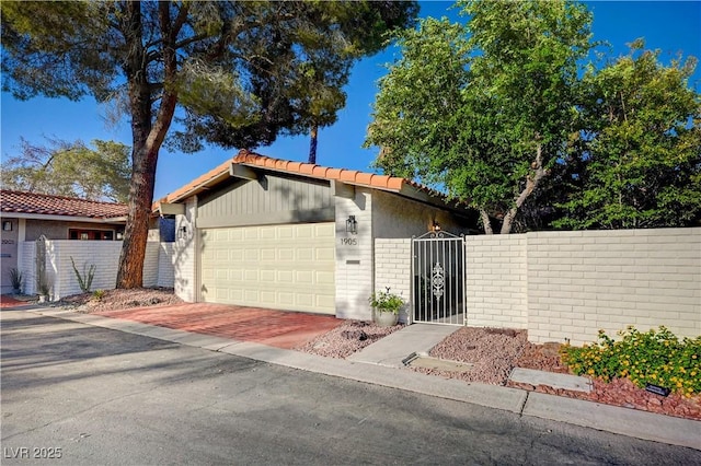 1905 Plaza Del Padre, Las Vegas, NV 89102 - mid-century modern home featuring a garage, a tiled roof, a gate, and decorative driveway