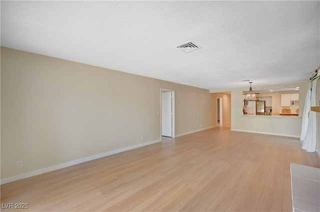 1905 Plaza Del Padre, Las Vegas, NV 89102 - unfurnished living room with light wood-style floors and a chandelier