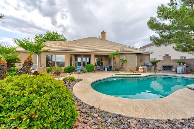 1704 River Birch St, Las Vegas, NV 89117 - swimming pool featuring a fireplace, a patio area, and french doors