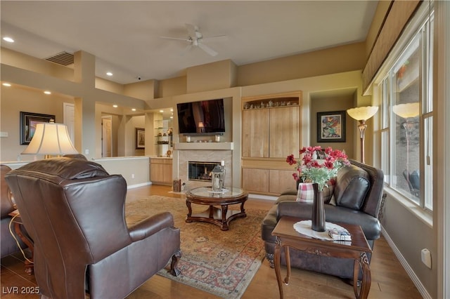 1704 River Birch St, Las Vegas, NV 89117 - living room featuring a ceiling fan, a high end fireplace, recessed lighting, wood finished floors, and built in shelves