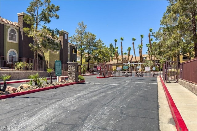 7950 W Flamingo Rd Unit 1024, Las Vegas, NV 89147 - view of asphalt street featuring a gate, curbs, a gated entry, and sidewalks