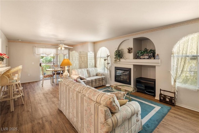 7950 W Flamingo Rd Unit 1024, Las Vegas, NV 89147 - living area featuring a glass covered fireplace, wood finished floors, ceiling fan, and ornamental molding