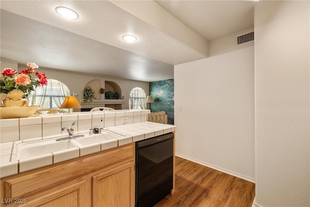 7950 W Flamingo Rd Unit 1024, Las Vegas, NV 89147 - kitchen featuring dishwasher, tile countertops, light wood finished floors, and light brown cabinetry