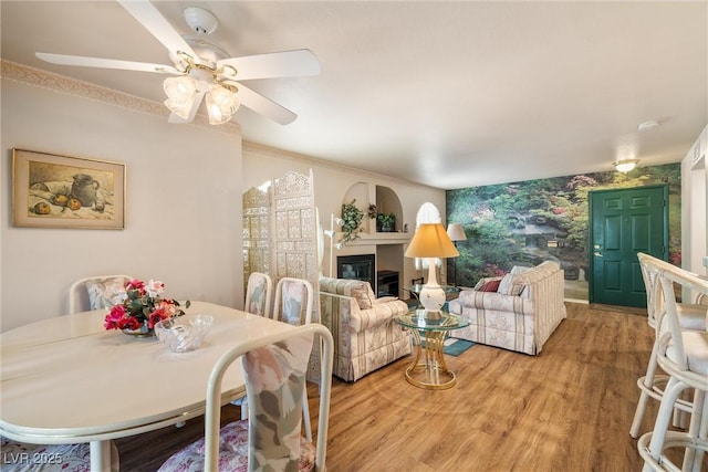 7950 W Flamingo Rd Unit 1024, Las Vegas, NV 89147 - living area with light wood-style floors, a ceiling fan, a glass covered fireplace, and wallpapered walls