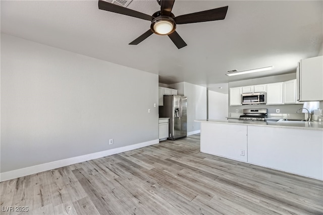 1038 Silver Creek Ave, Las Vegas, NV 89183 - kitchen with appliances with stainless steel finishes, light wood finished floors, a ceiling fan, white cabinets, and light countertops