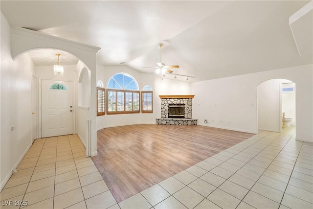 901 E Jaybird St, Pahrump, NV 89048 - entryway with arched walkways, ceiling fan, light tile patterned floors, lofted ceiling, and a stone fireplace