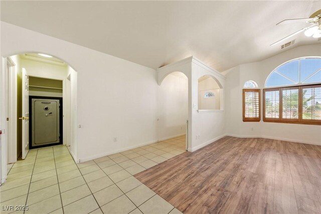 901 E Jaybird St, Pahrump, NV 89048 - unfurnished room with a ceiling fan, lofted ceiling, arched walkways, and light tile patterned floors