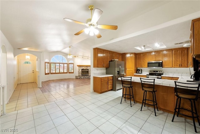 901 E Jaybird St, Pahrump, NV 89048 - kitchen with appliances with stainless steel finishes, open floor plan, ceiling fan, arched walkways, and vaulted ceiling