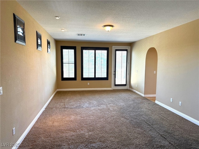 585 Via Alhambra, Las Vegas, NV 89123 - spare room featuring carpet floors, arched walkways, a textured ceiling, and a textured wall