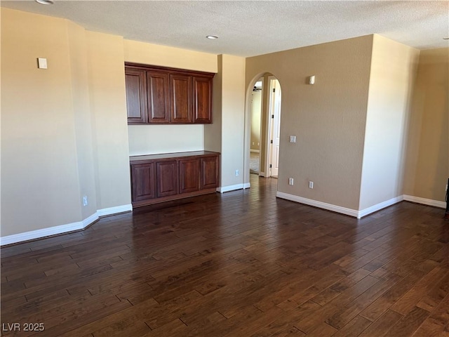 585 Via Alhambra, Las Vegas, NV 89123 - unfurnished room featuring arched walkways, dark wood-style flooring, and a textured ceiling