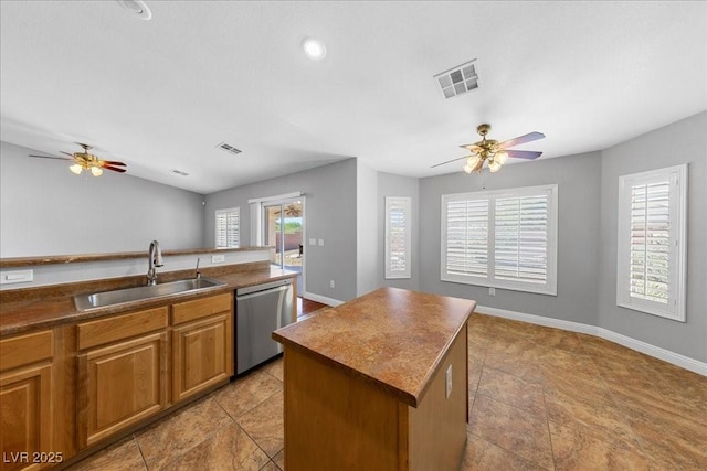 4029 Ricebird Way N, Las Vegas, NV 89084 - kitchen with stainless steel dishwasher, a ceiling fan, brown cabinets, and dark countertops