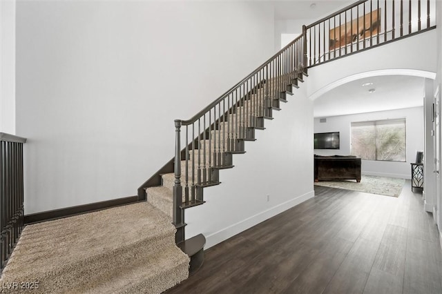 2229 Armacost Dr, Henderson, NV 89074 - staircase featuring arched walkways, wood finished floors, and a high ceiling