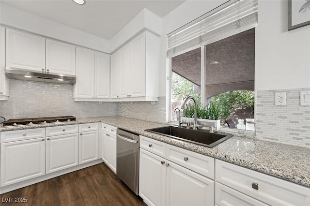 2229 Armacost Dr, Henderson, NV 89074 - kitchen featuring dishwasher, under cabinet range hood, black stovetop, dark wood-type flooring, and tasteful backsplash