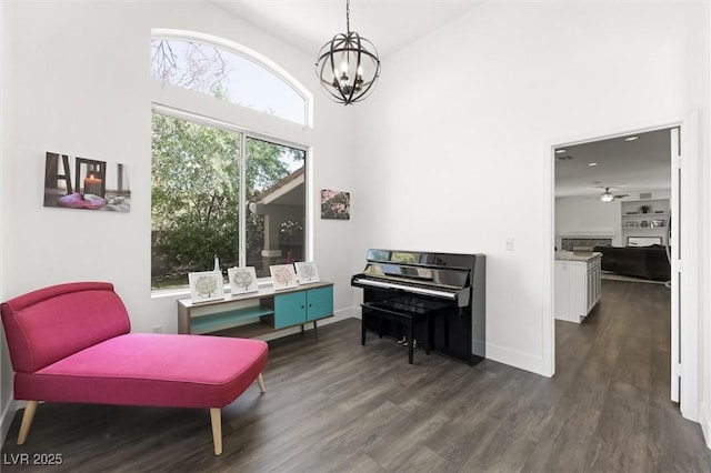 2229 Armacost Dr, Henderson, NV 89074 - sitting room with dark wood-type flooring, a chandelier, a towering ceiling, a ceiling fan, and a fireplace