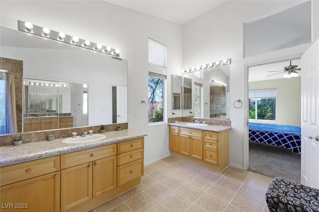 2229 Armacost Dr, Henderson, NV 89074 - full bathroom with two vanities, tile patterned floors, a high ceiling, connected bathroom, and ceiling fan
