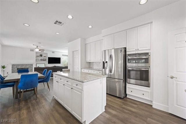 2229 Armacost Dr, Henderson, NV 89074 - kitchen with stainless steel appliances, white cabinetry, a kitchen island, and recessed lighting