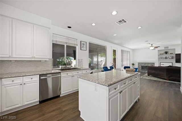 2229 Armacost Dr, Henderson, NV 89074 - kitchen with dishwasher, ceiling fan, a stone fireplace, a kitchen island, and recessed lighting
