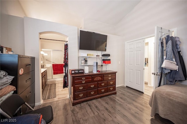 7231 Sequoia Springs Dr, Las Vegas, NV 89147 - bedroom with arched walkways, wood finished floors, a spacious closet, connected bathroom, and vaulted ceiling